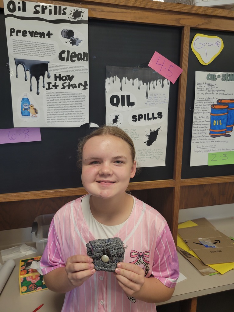 A student holds her completed project of a purse crocheted from plastic bags