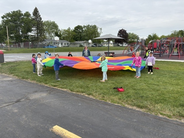 4K students play with a parachute outside