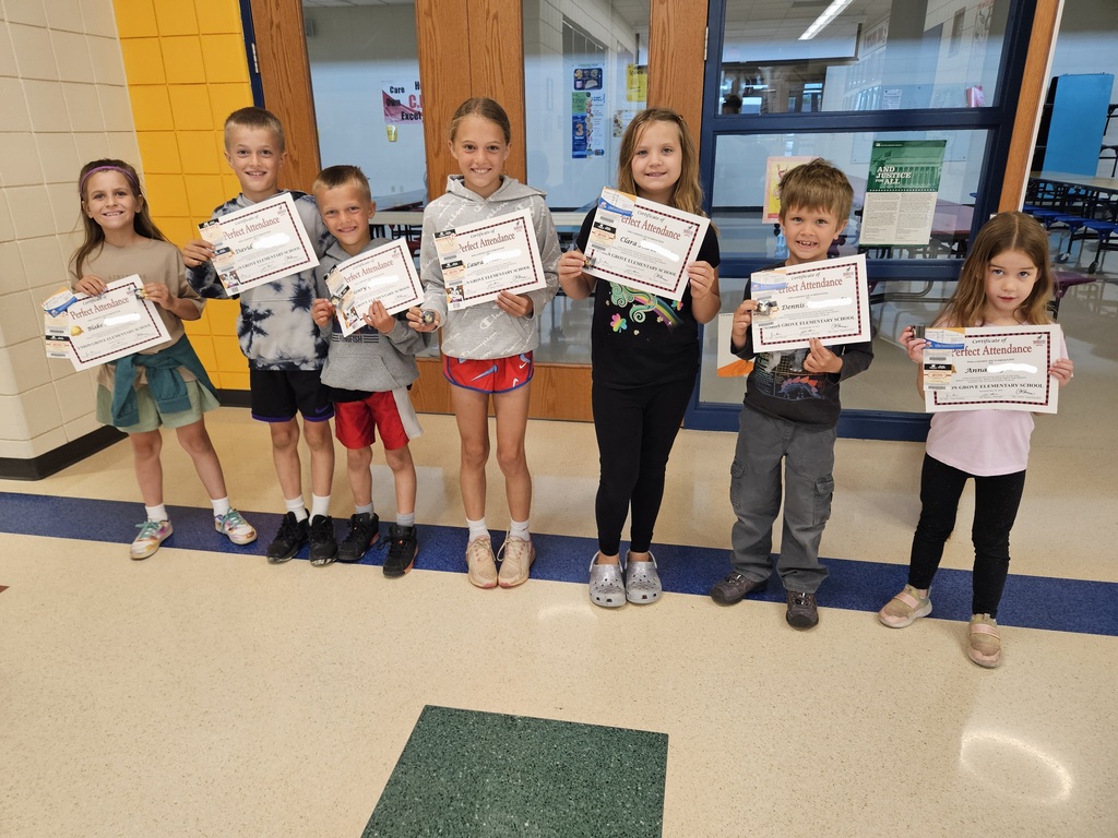 perfect attendance students pose for a photo with their awards