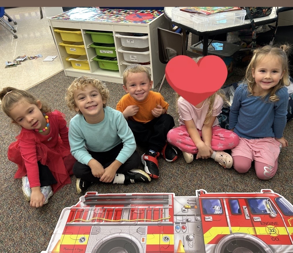 4K students pose for a photo with their completed puzzle