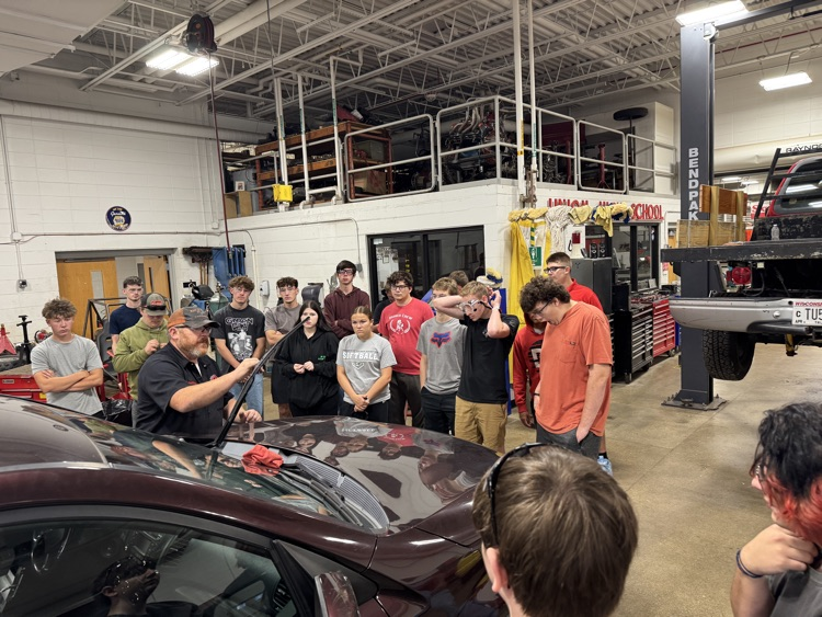 students examining car