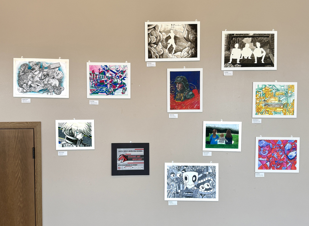 A wall displays various framed artworks, including abstract and portrait styles, with some featuring black borders. The wall is light-colored.
