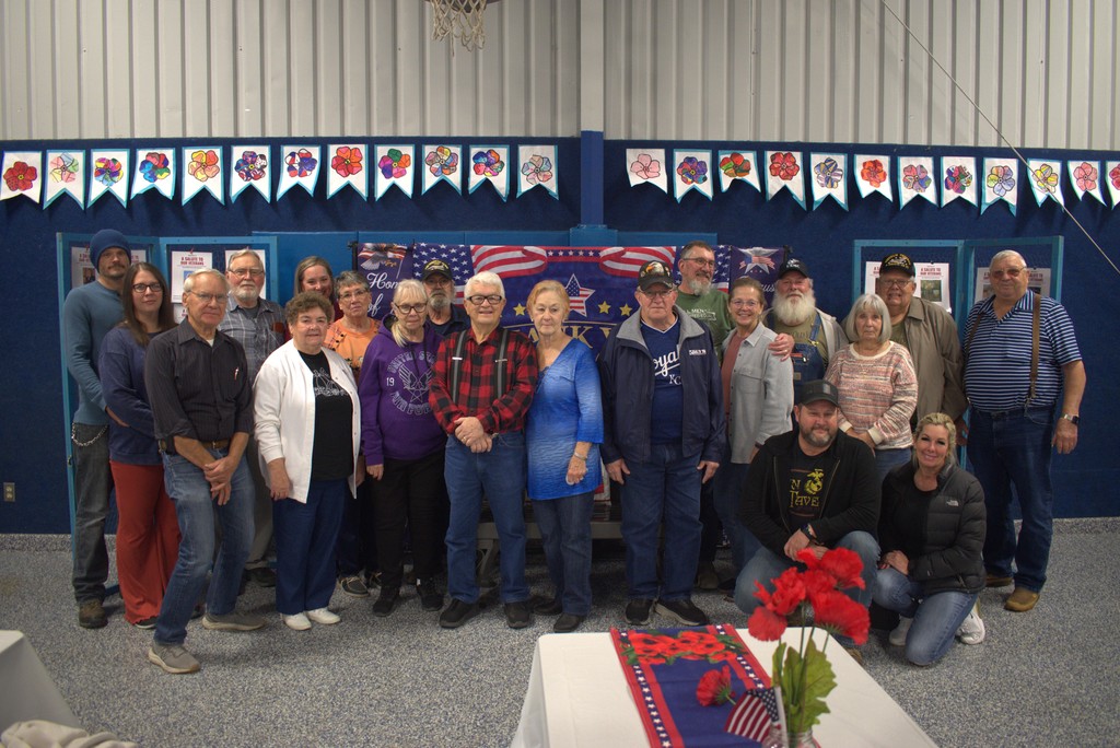 Local veterans and their families stand together for a group photo.