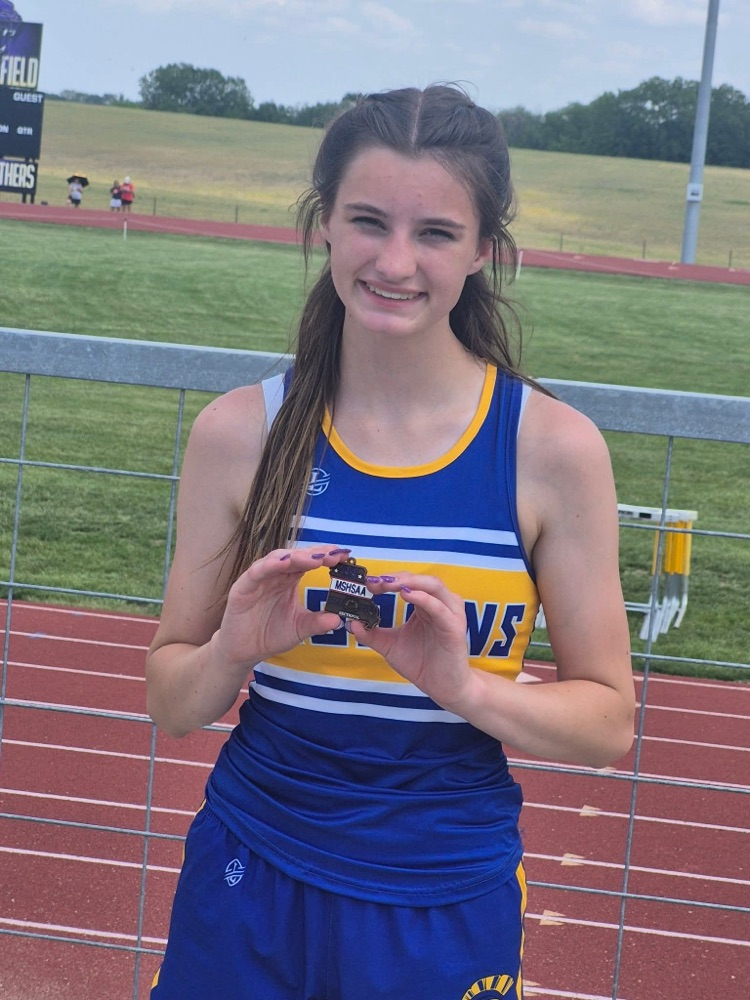 picture of Remie holding her medal for 4th place in the 100m hurdles.