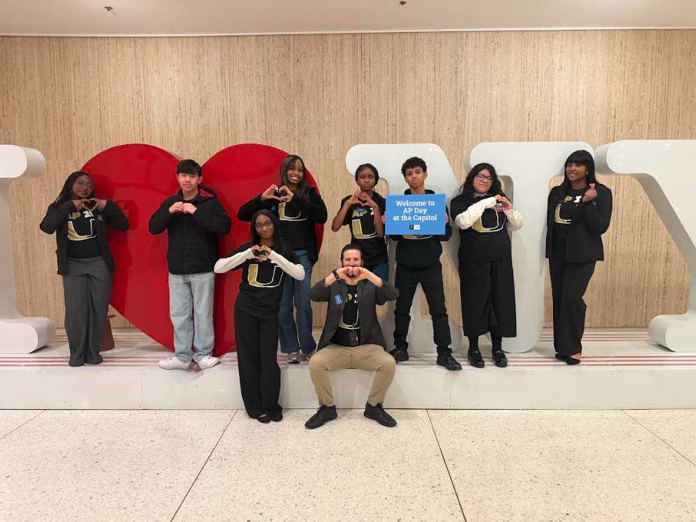 students in front of ny sign