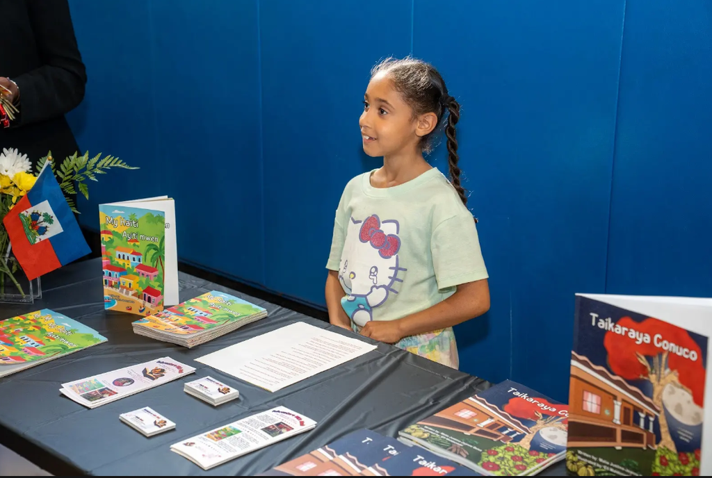 Student standing at table with books
