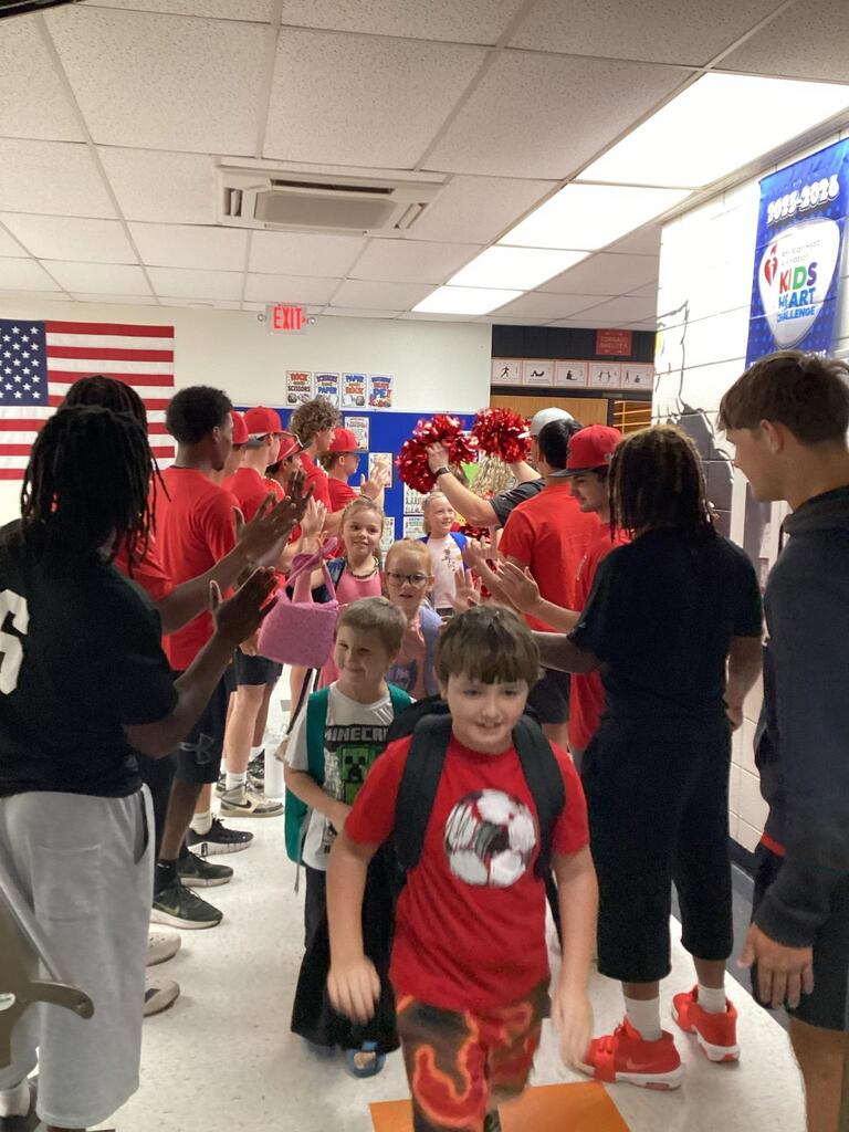 ACC athletes creating a tunnel for a WBE student.
