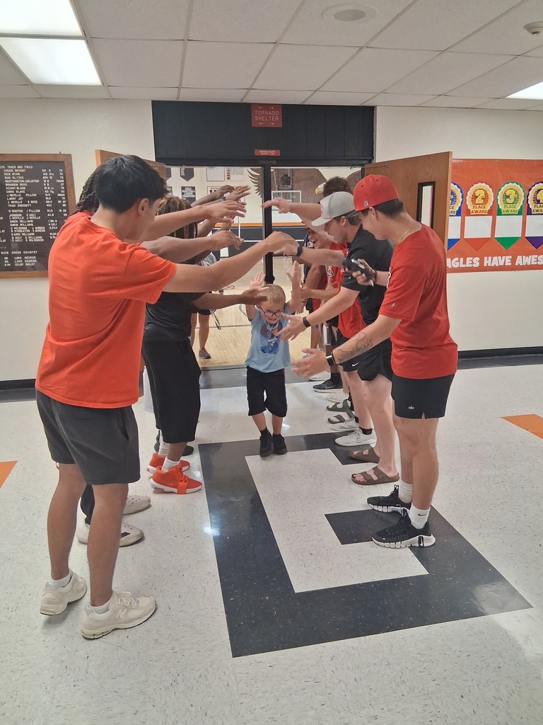 ACC athletes creating a tunnel for a WBE student.