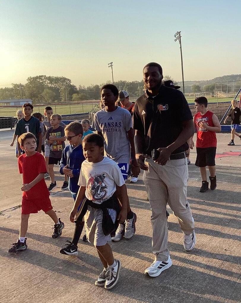 Coach Howard walking with WBE students