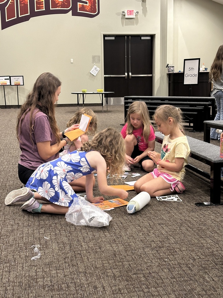 leader helping students with a craft project