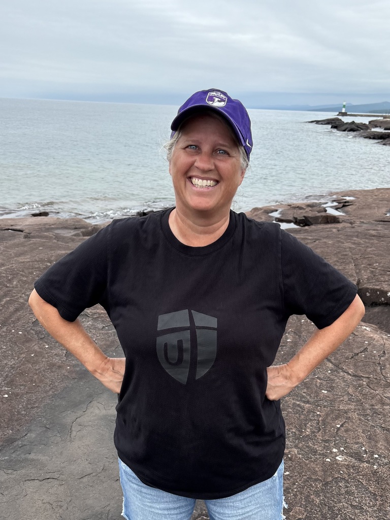 teacher standing on the rocks next to Lake Superior in Grand Marais