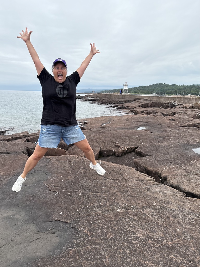teacher standing on the rocks next to Lake Superior in Grand Marais
