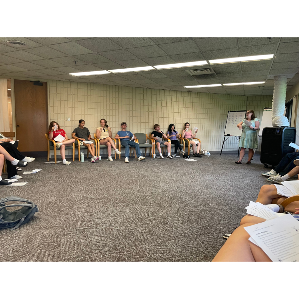 teacher speaking to a group of students at a leadership retreat