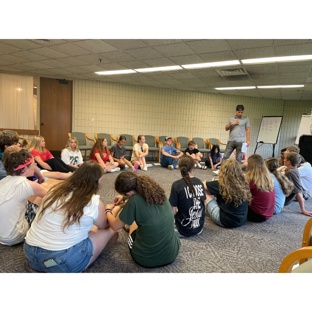 teacher speaking to a group of students at a leadership retreat