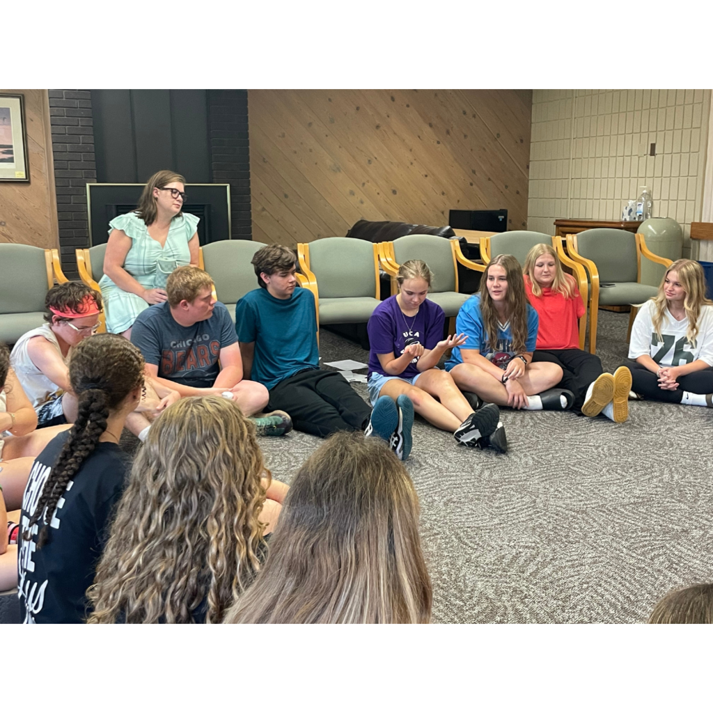 teacher speaking to a group of students at a leadership retreat