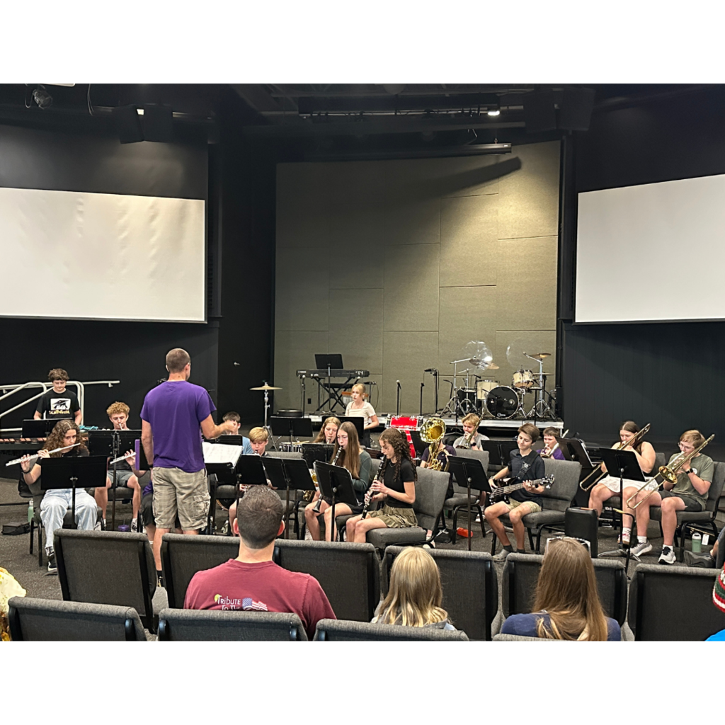 group of 8th-12th grade band students performing a concert