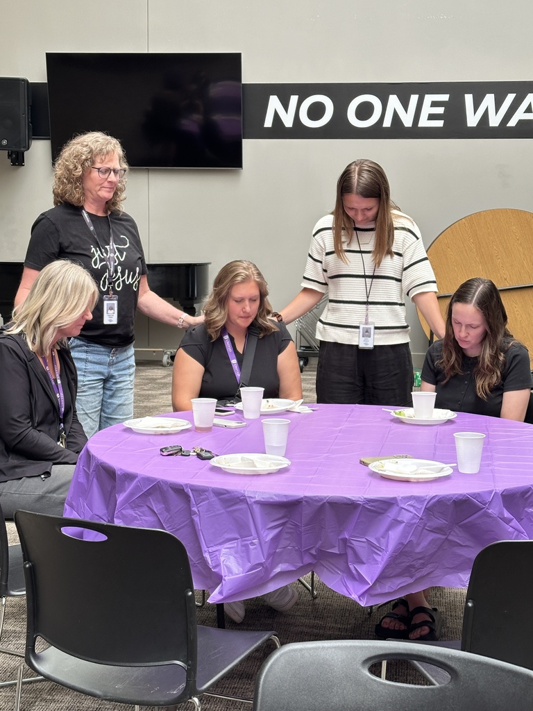 church staff laying hands on teachers while they pray
