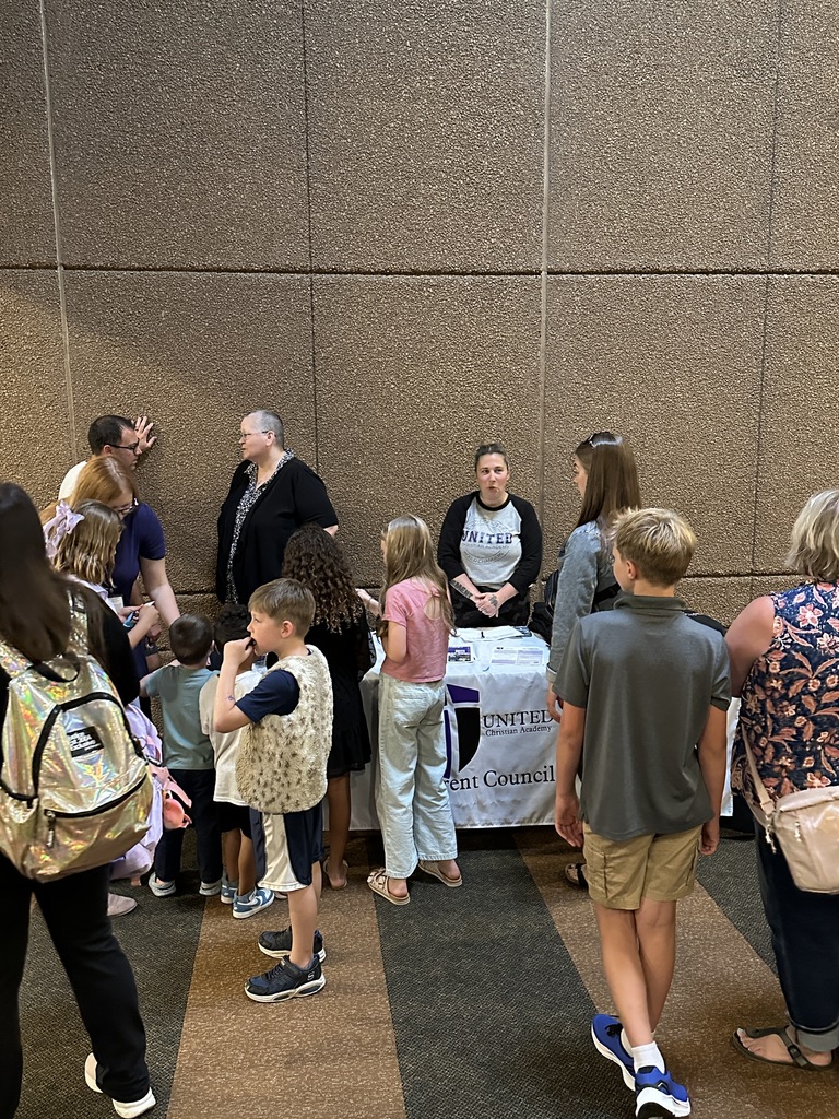 parents standing by an information table having conversations
