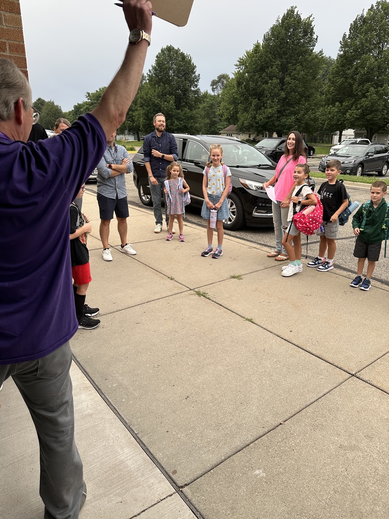 elementary principal welcoming students into the building