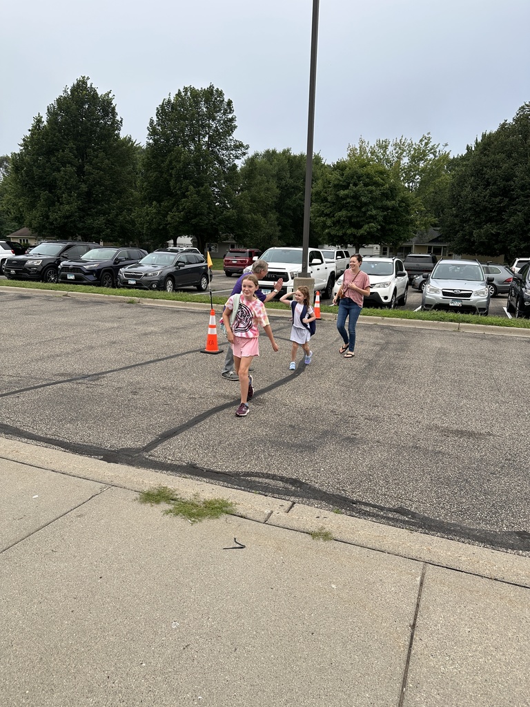 elementary principal welcoming students into the building