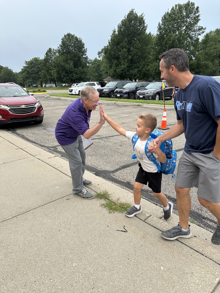 elementary principal welcoming students into the building