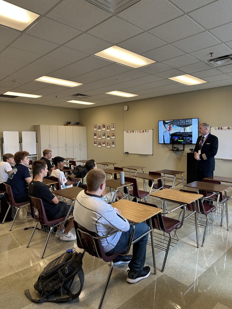 aviation teacher standing at the front of a classroom talking to students