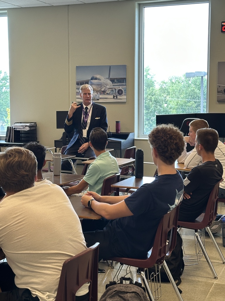 aviation teacher standing at the front of a classroom talking to students