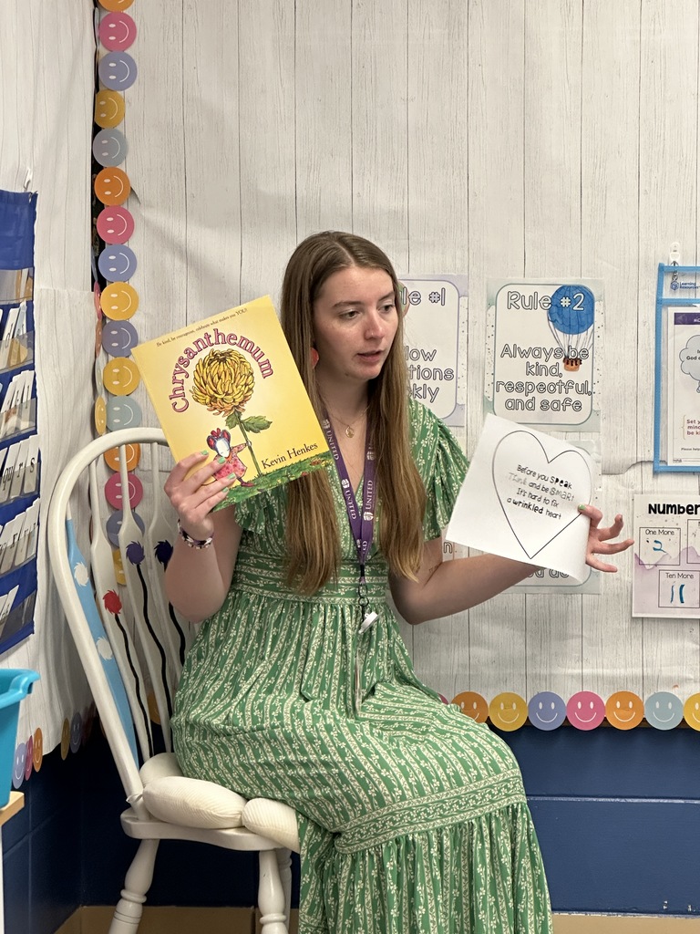 teacher holding up the book she is reading and a handout