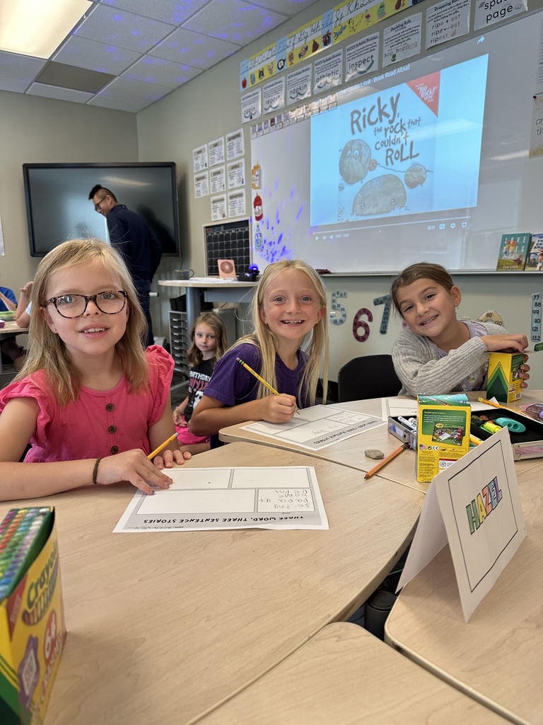 three girls working on a project at their desks
