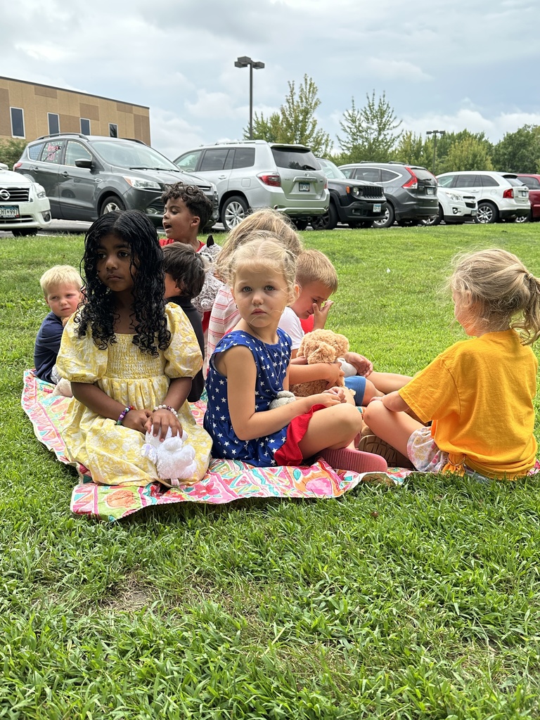 group of students sitting on a picnic blanket
