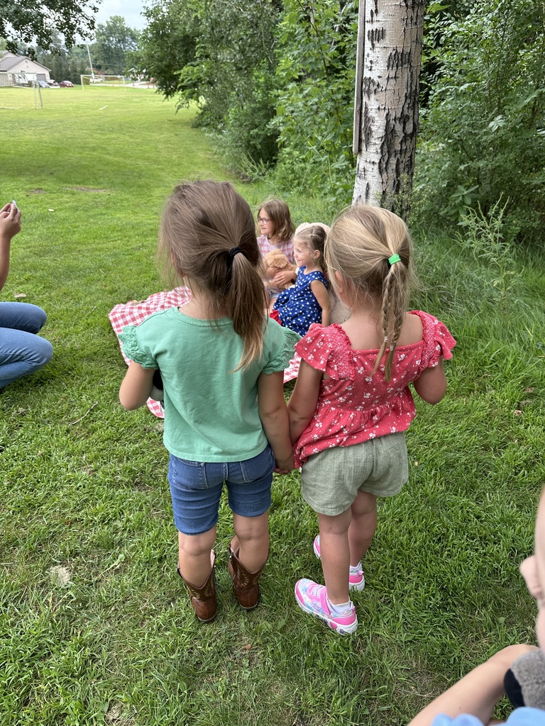 two girls holding hands while they wait in line to have their pictures taken