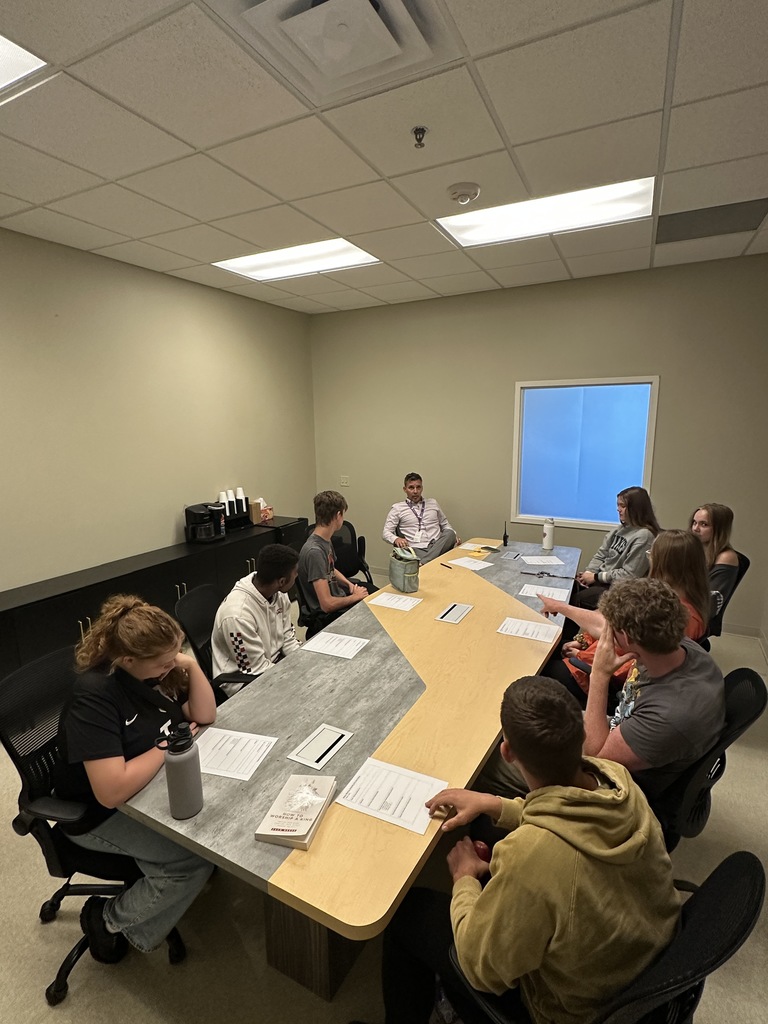 head of school with a group of senior leaders meeting around a big conference table