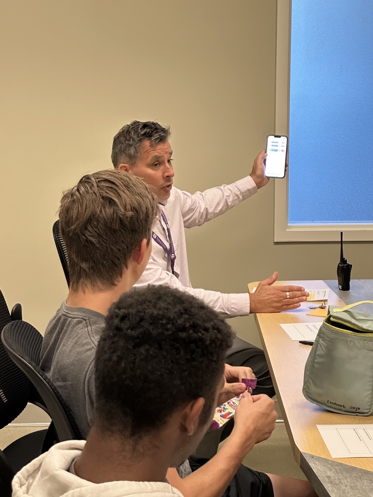 head of school showing the senior leaders a chart on his phone
