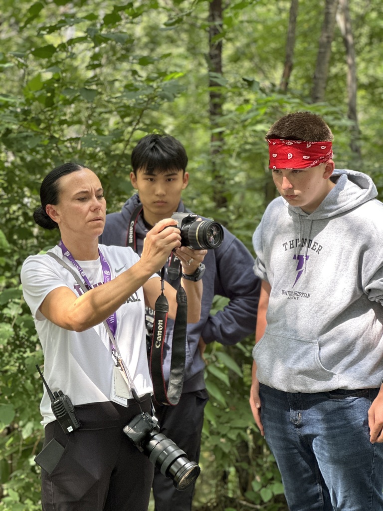 teacher and student looking at a camera to see the photos they've taken