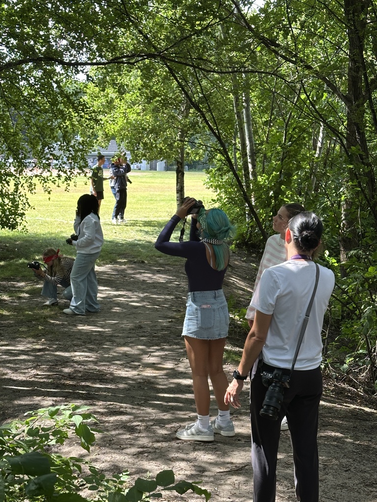 teacher observing students taking photographs
