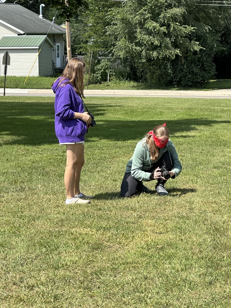 students guiding a blindfolded classmate around so they can take photographs outside