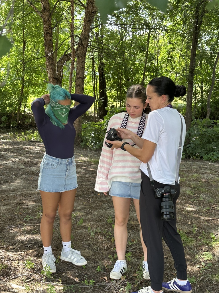 teacher and student looking at a camera to see the photos they've taken