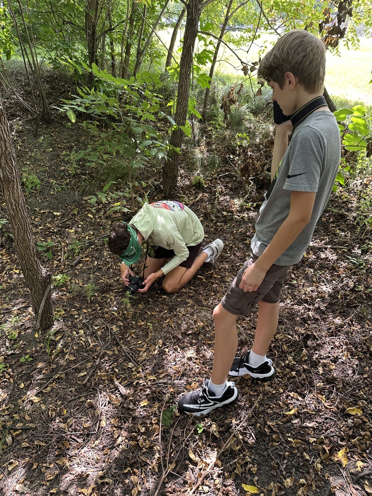 students guiding a blindfolded classmate around so they can take photographs outside
