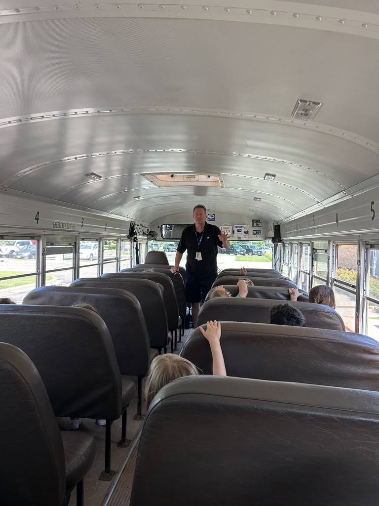 bus driver talking to kindergarten students while they're sitting in a bus