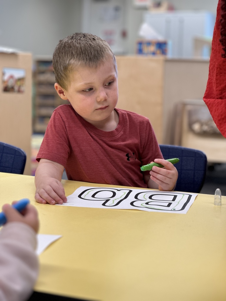 pre-k student practicing writing his letters