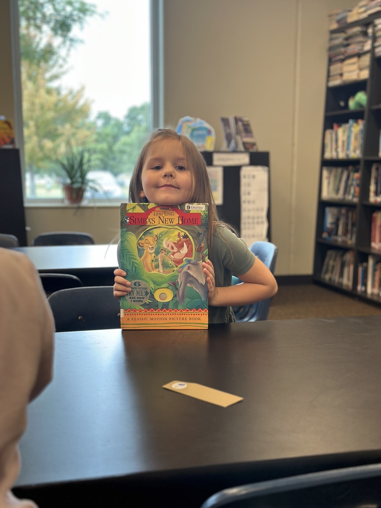 kindergarten student showing the library book she chose
