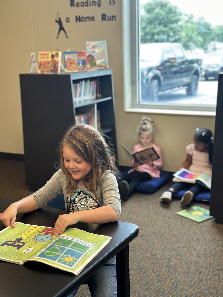 kindergarten students looking at library books