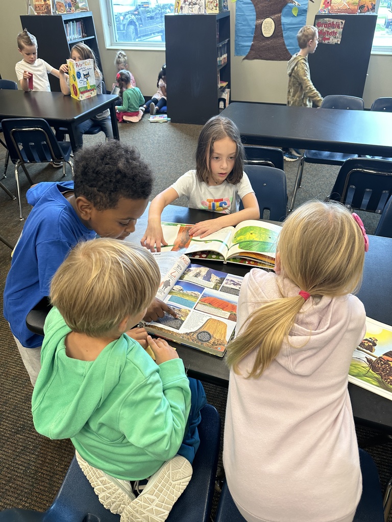 kindergarten students looking at library books