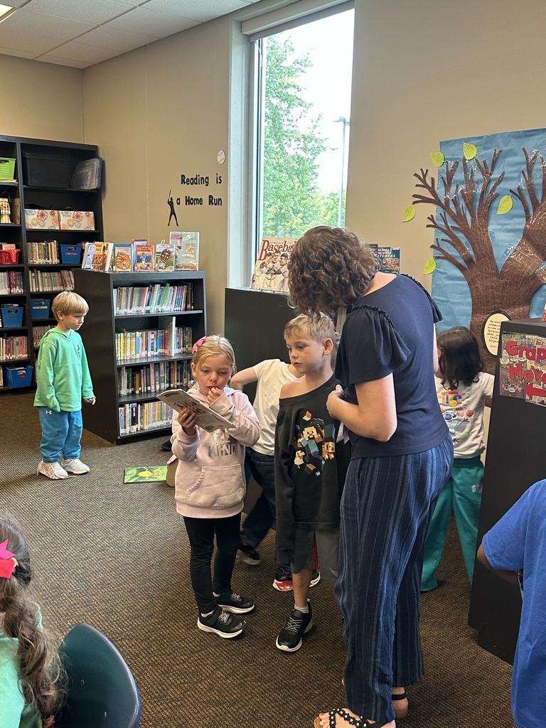 librarian showing students where to find books