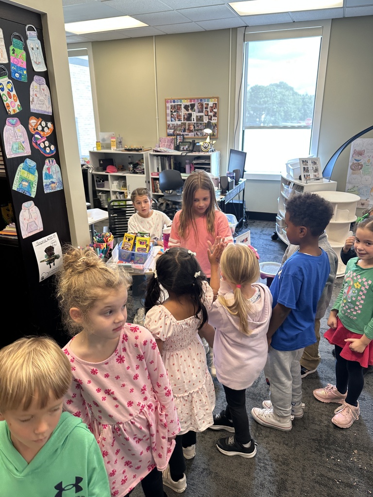 3rd grade girl giving kindergarteners high fives