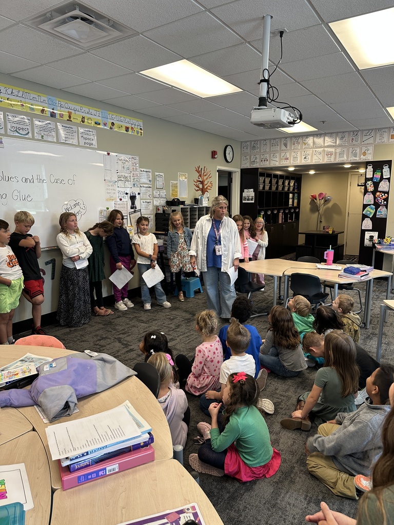 3rd graders reading in front of a kindergarten class