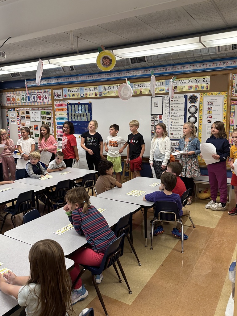 3rd graders reading in front of a kindergarten class