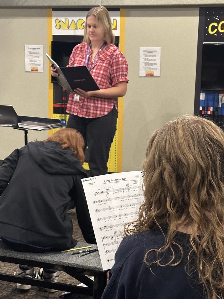 Choir director leading her high school students