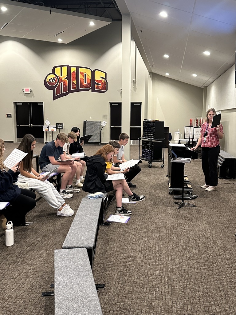 Choir director leading her high school students