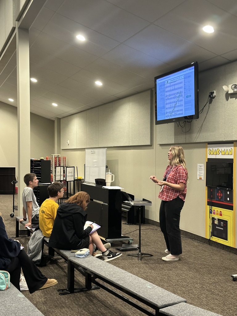 Choir director leading her high school students